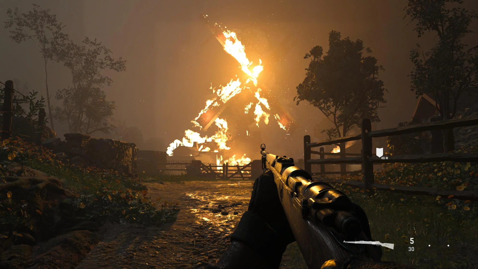 Солдат с винтовкой направляется к горящей мельнице в игре Call of Duty Vanguard, вид от первого лица.