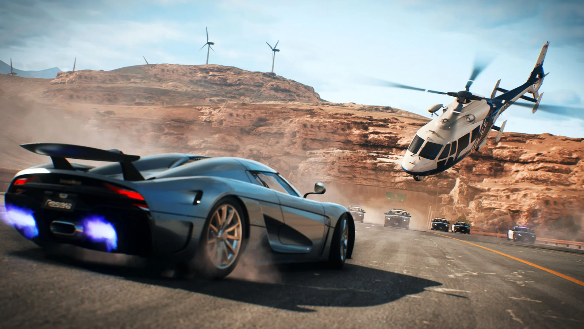 Скриншот из игры Need for Speed Payback, показывающий высокоскоростную погоню с участием суперкара и полицейского вертолета на фоне пустыни.