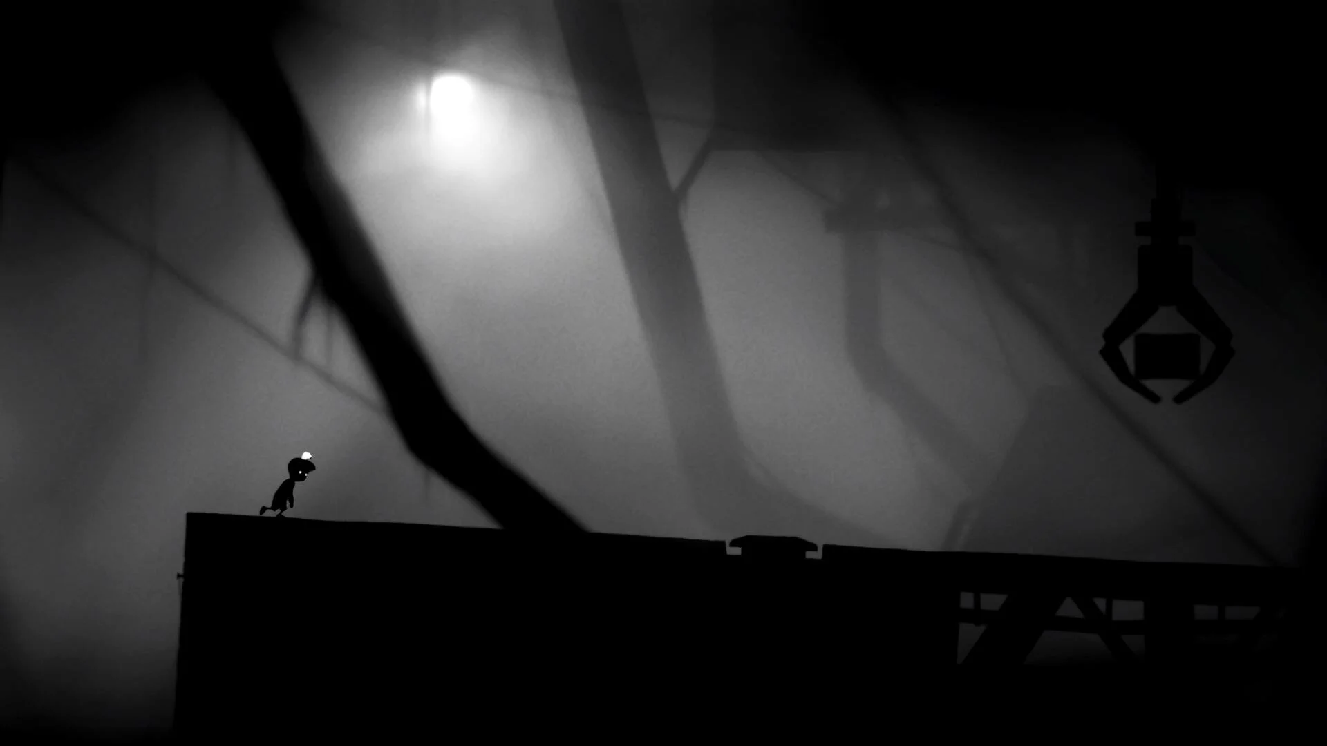 Мальчик бежит по платформе в игре Limbo