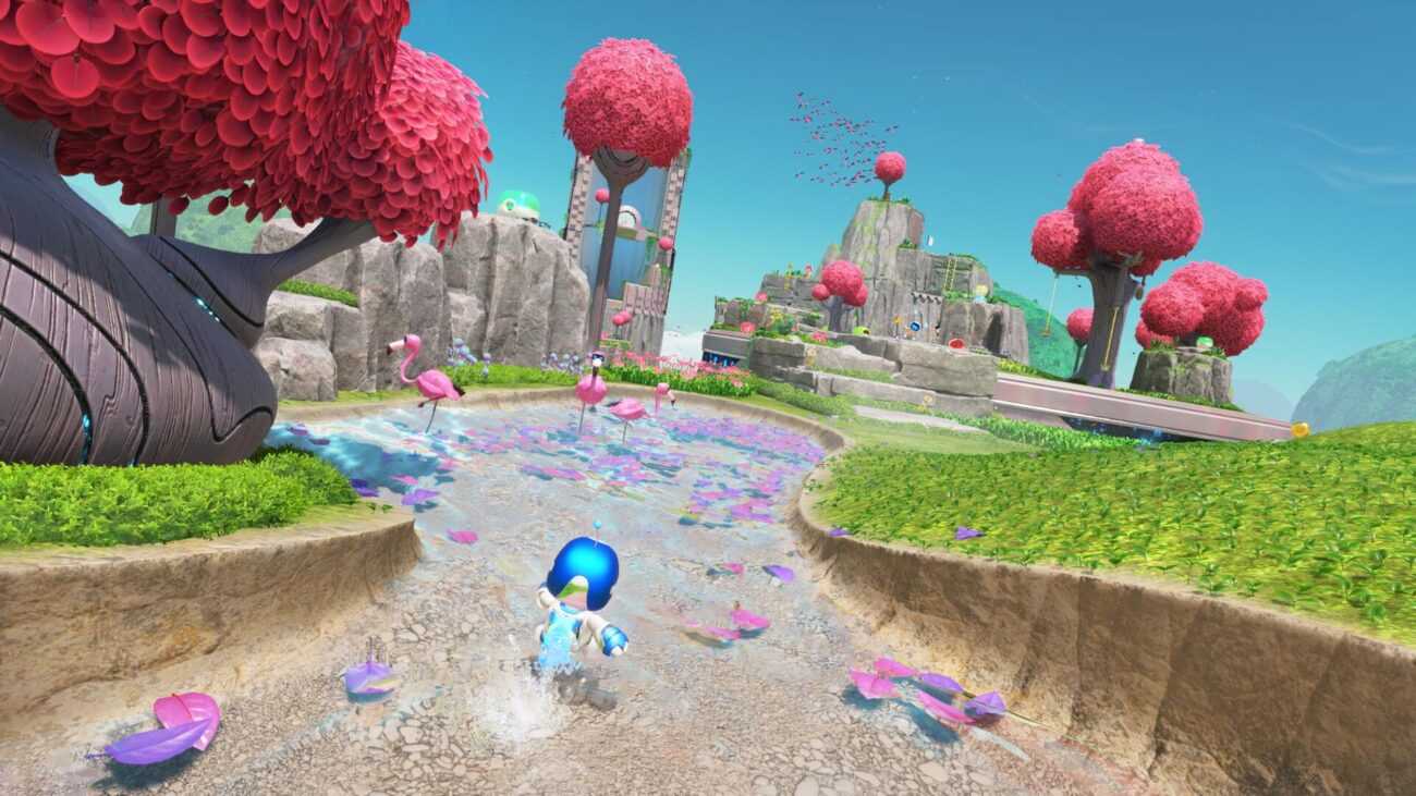 Astro Bot исследует живописный мир с розовыми деревьями и фламинго на PlayStation 5.