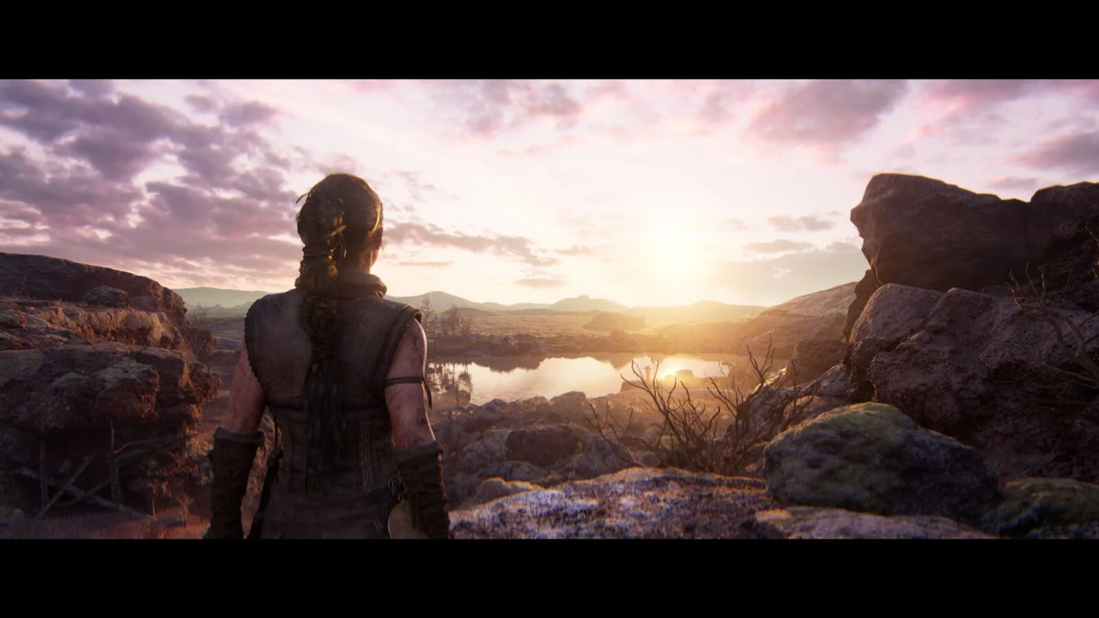 Senua смотрит на рассвет над горами в Hellblade II